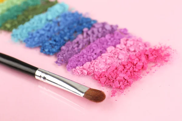 Ombretto schiacciato arcobaleno e pennello professionale per il trucco su sfondo rosa — Foto Stock