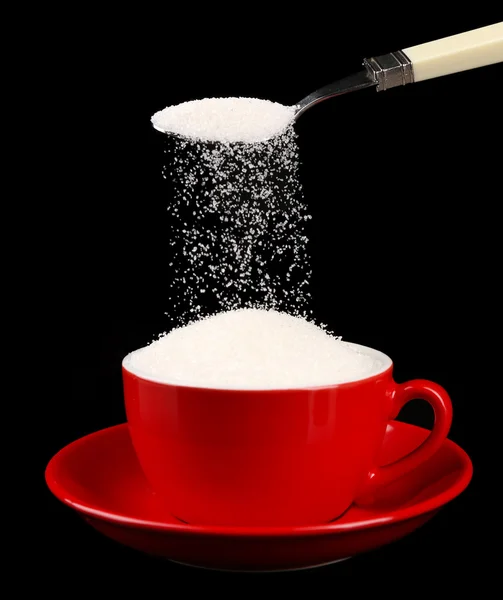 Açúcar em xícara isolado em preto — Fotografia de Stock