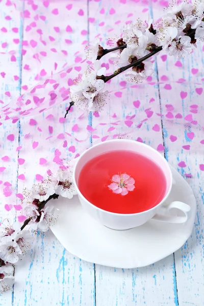 Fragrant tea with flowering branches on wooden table close-up — Stock Photo, Image