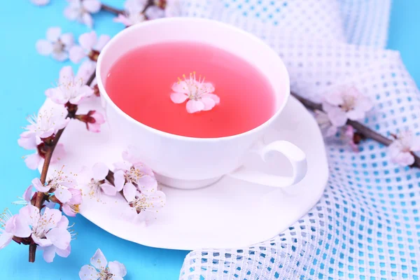 Voňavý čaj s kvetoucí větve na dřevěný stůl detail — Stock fotografie