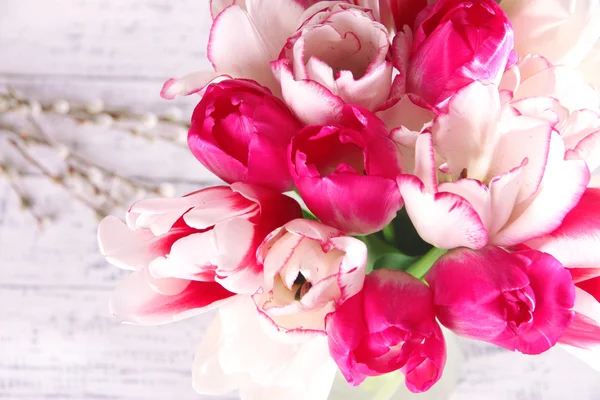 Schöne Tulpen im Glaskrug auf hellem Hintergrund — Stockfoto
