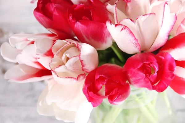 Schöne Tulpen im Glaskrug auf hellem Hintergrund — Stockfoto