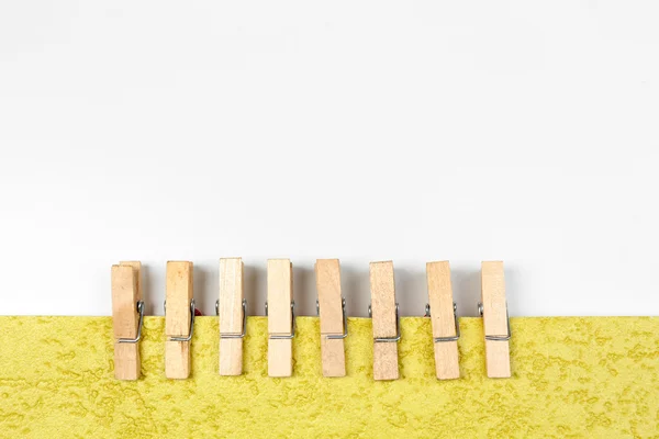Barevné dřevěné kolíky s papírem izolovaných na bílém — Stock fotografie