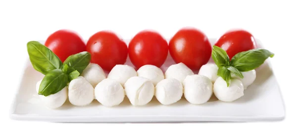 Bolinhas de queijo mussarela saborosas com manjericão e tomates vermelhos, isoladas em branco — Fotografia de Stock