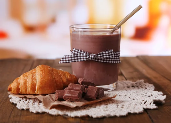 Csokoládés tej üvegből, fából készült asztal, a világos háttér — Stock Fotó