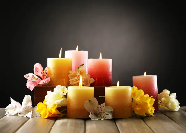 Schöne Kerzen mit Blumen auf Holzgrund — Stockfoto