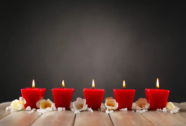 Hermosas velas con flores sobre fondo de madera — Foto de Stock