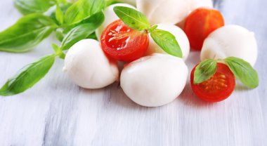 ahşap masa üstünde domates ve fesleğen ile lezzetli mozzarella peyniri