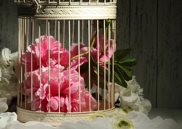 Prachtige decoratieve kooi met mooie bloemen — Stockfoto