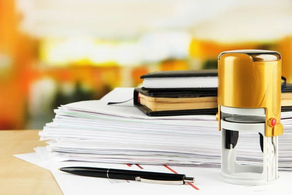 Stamp with notepads and papers on table on bright background — Stock Photo, Image