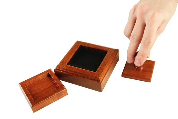 Mão segurando selo de madeira isolado no branco — Fotografia de Stock