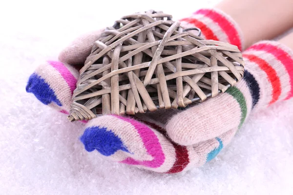 Female hands in mittens with heart on snow background — Stock Photo, Image