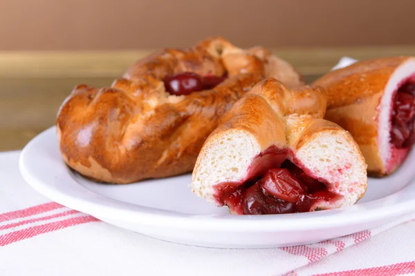 Tablo yakın çekim tabağa kiraz ile taze pişmiş pasties — Stok fotoğraf