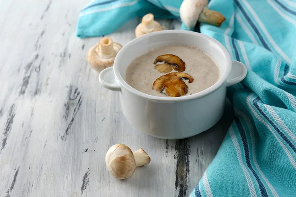 Mushroom soup in white pot, on napkin,  on wooden background — Stock Photo, Image