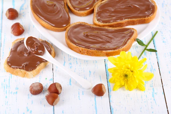 Pan con avellana de chocolate dulce extendido en el plato en la mesa —  Fotos de Stock
