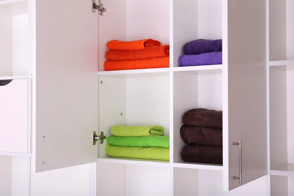 Białe półki z kolorowe ręczniki z bliska — Zdjęcie stockowe