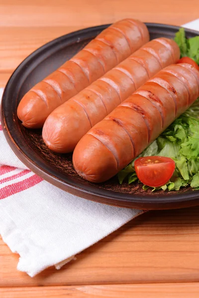 Жареная колбаса на тарелке на столе крупным планом — стоковое фото