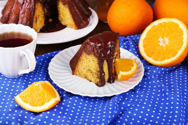 Pièce de gâteau délicieux avec des oranges sur la table close-up — Photo
