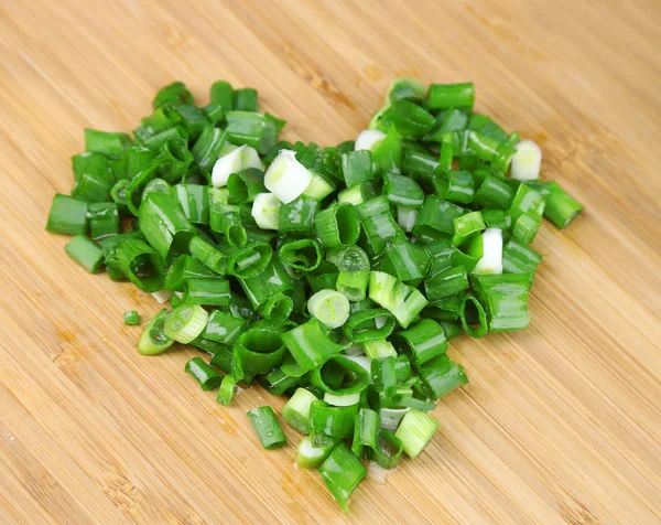 Heart shape of chopped herbs  and fresh vegetables, on wooden background — Stock Photo, Image