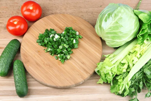 Heart shape of chopped herbs  and fresh vegetables, on wooden background — Stock Photo, Image