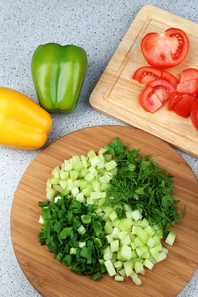 Složení s nasekané bylinky na dřevěném prkénku a čerstvou zeleninu, na kuchyňský stůl pozadí — ストック写真
