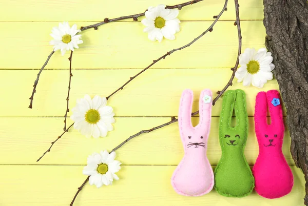 Composição com coelhos de Páscoa artesanais engraçados em fundo de madeira — Fotografia de Stock