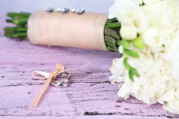Bellissimo bouquet da sposa e anelli su sfondo di legno — Foto Stock
