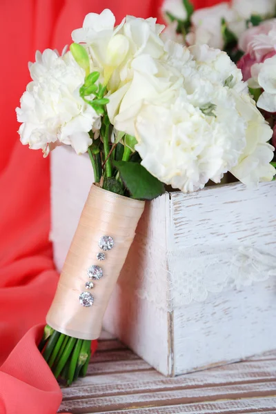 Hermosa composición de la boda con ramo en la mesa sobre fondo de tela —  Fotos de Stock