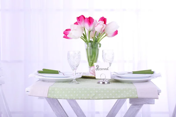 New table with place settings on light background — Stock Photo, Image