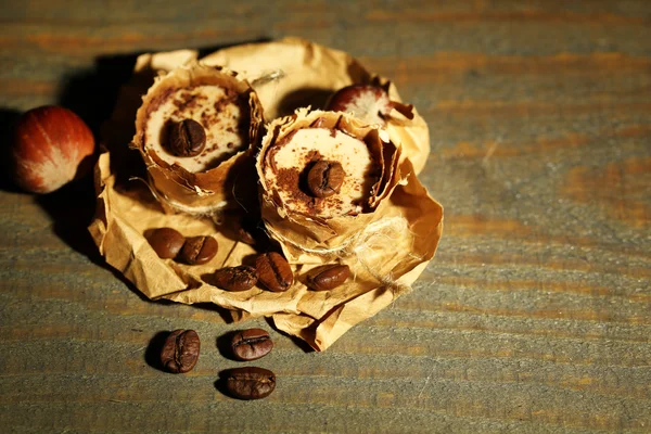 Tasty chocolate candies with coffee beans and nuts on wooden background — Stock Photo, Image