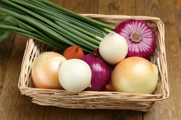 Different raw onion on wooden background — Stock Photo, Image