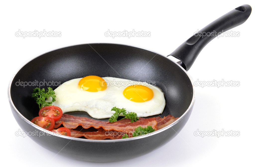 Scrambled eggs and bacon on frying pan isolated on white