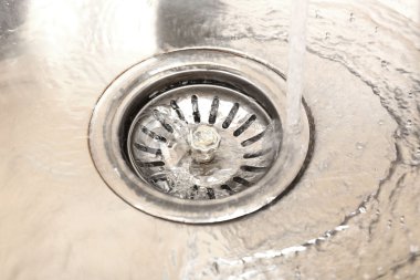 Water flowing down hole in kitchen sink clipart