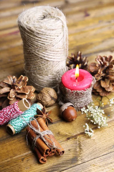 Composition with natural bump, candle, thread, cinnamon sticks on wooden background — Stock Photo, Image