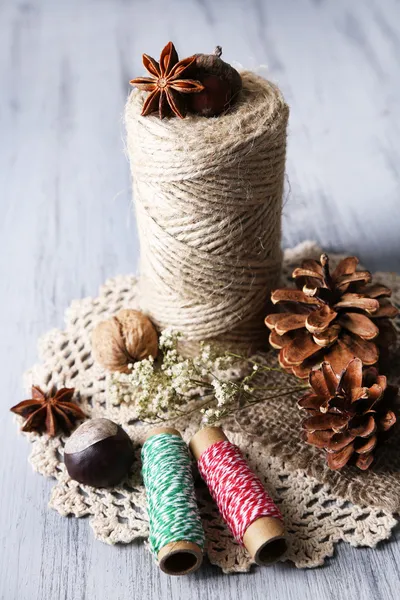 Composition avec bosse naturelle, fil, bâtons de cannelle sur fond en bois — Photo