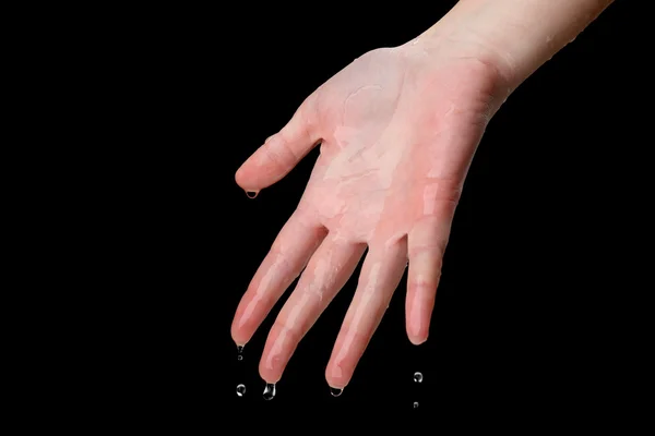 Main humaine avec éclaboussures d'eau sur eux sur fond noir — Photo