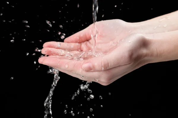 Menselijke handen met water spatten op hen op zwarte achtergrond — Stockfoto