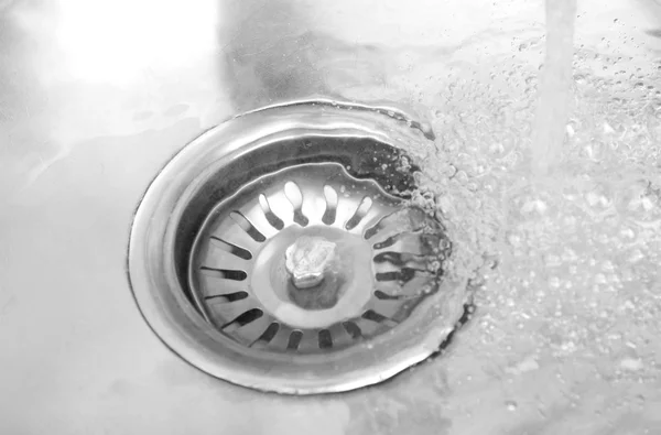 Water flowing down hole in kitchen sink — Stock Photo, Image