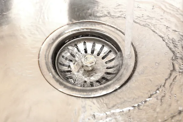 Water flowing down hole in kitchen sink — Stock Photo, Image