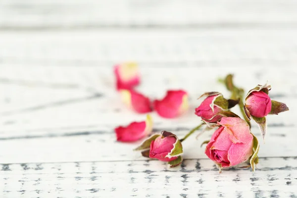 Beautiful pink dried roses on old wooden background — Stock Photo, Image