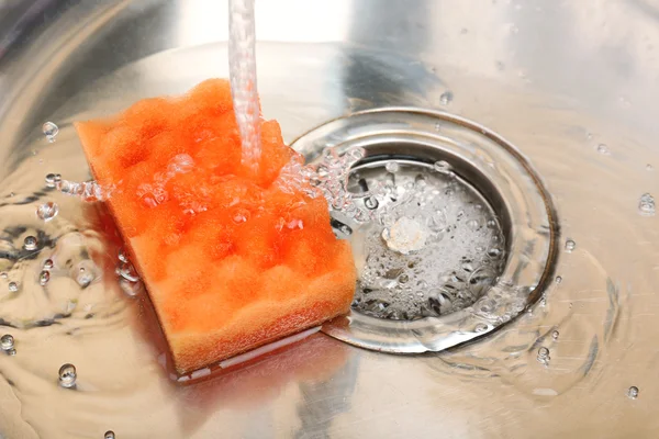 Acqua che scorre giù foro nel lavello della cucina — Foto Stock