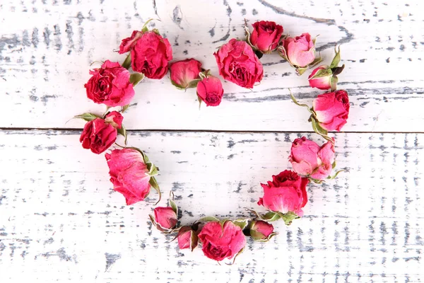 Herz aus schönen rosa getrockneten Rosen auf altem Holzgrund — Stockfoto