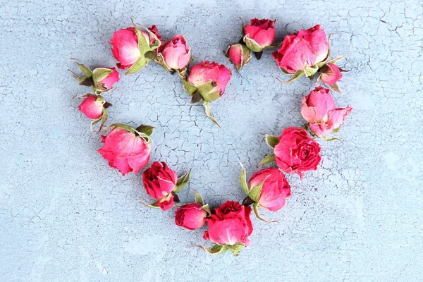 Heart of beautiful pink dried roses on old wooden background — Stock Photo, Image