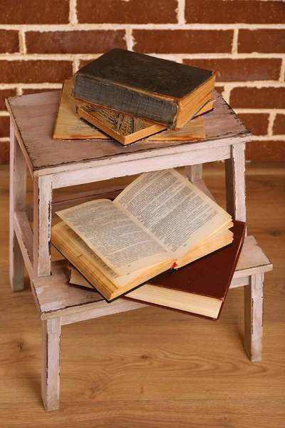 Books on wooden ladder on  color wall background — Stock Photo, Image