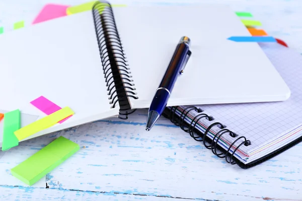 Cuaderno, bolígrafo y pegatinas sobre fondo de madera —  Fotos de Stock