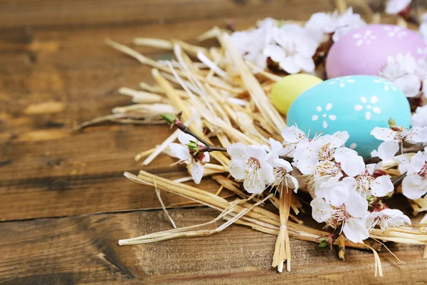 Húsvéti összetétele, virágzó ágakat a közeli fából készült asztal — Stock Fotó