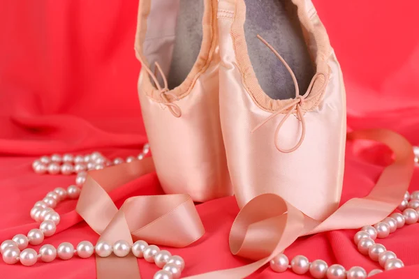 Ballet pointe shoes on red fabric background — Stock Photo, Image