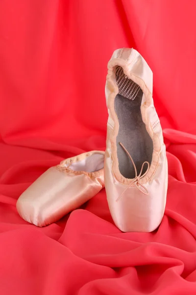 Ballet pointe schoenen op rode stof achtergrond — Stockfoto