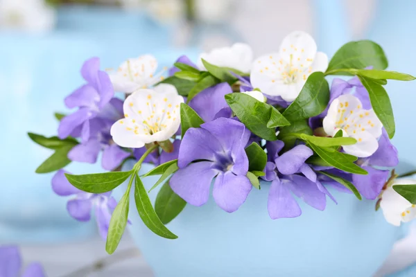 Hermosas flores de primavera en copa sobre mesa de madera — Foto de Stock