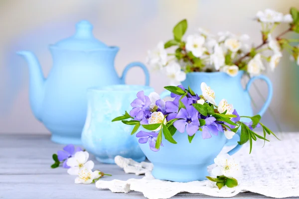 Прекрасные весенние цветы в чашках на деревянном столе — стоковое фото